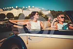 Two stylish ladies in a classic convertible