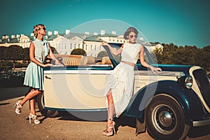 Two stylish ladies near classic car