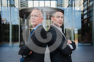Two succesful mature business men looking at camera with serious expression. A pair of executive mid adult males wearing