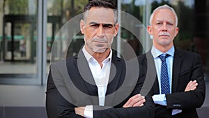 Two succesful mature business men looking at camera with serious expression. A pair of executive mid adult males wearing