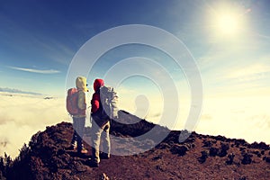 Two successful backpackers enjoy the beautiful landscape on sunrise mountian photo