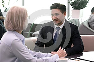 Two successful business people meeting in cafe and communicating