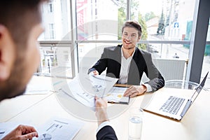 Two successful businessmen sitting and creating business plan on meeting