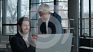 Two successful excited Caucasian businessmen workers looking computer screen in office men business partners investors