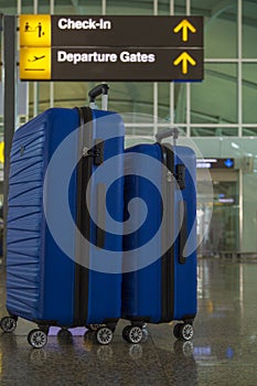 Two suitcases in the airport departure lounge, summer vacation concept, traveler suitcases in airport terminal waiting area,