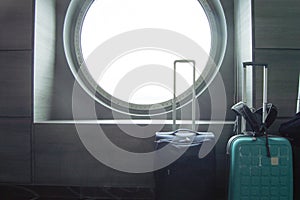 Two suitcases for traveling in front of the round porthole of the ship, the concept of leisure or business trip