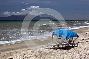 Two sun beds on an empty beach/