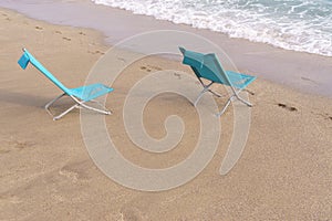 Two sun loungers on the sandy beach