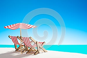 Two sun loungers under an umbrella on the sandy beach by the sea and the sky with copy space
