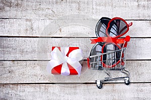 Two sunglasses in a supermarket trolley, gift box, concept of promotions