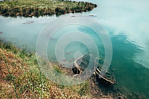 Two sunken wooden fisherman`s boats in the river water at the N