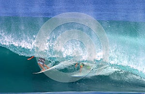 Two Surfers Surfing in One Tubing Wave photo