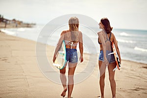 Two surferâ€™s girl on the beach. Fun sport on summer vacations