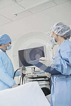 Two surgeons preparing for surgery, patient lying down