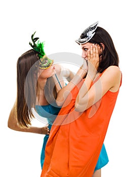 Two surprised young women wearing mask at masquera