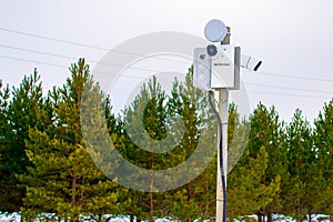 Two surveillance cams on top of a pole, seen from below against a blue sky