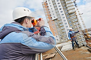 Two surveyors worker with theodolite