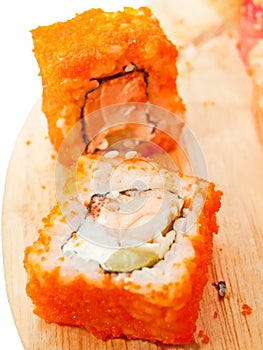 Two sushi roll with salmon and masago on the desk