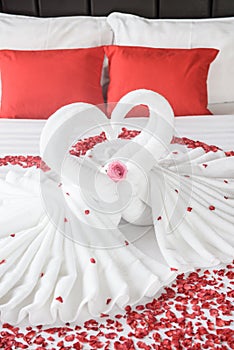 Two swans and heart made from towels on honeymoon bed