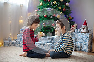 Two sweet children, boy brothers, opening presents on Christmas