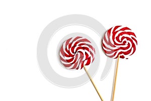 Two sweet lollipop with red, white spiral stripes colors on wooden stick isolated on white background.