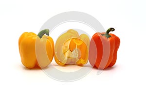 Two sweet peppers of yellow and orange color on a light background.