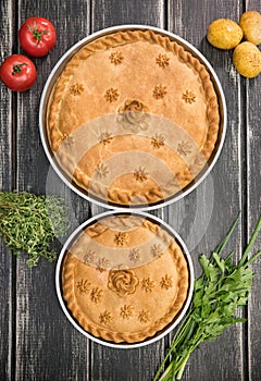 Two sweet potato pies with edible decorations on top - greens and tomatoes on the sides