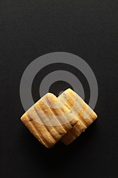 Two sweet and salted Cumin Cookies or Indian Jeera Cookies, on a black background.