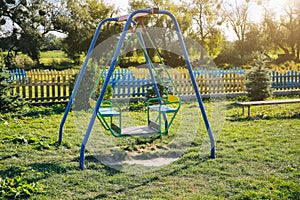 Two swings on children playground. Outdoors games for kids. Summer day