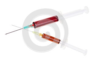 Two syringes with red liquid.