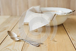 Two tablespoons on a background of linen cloth in bowl