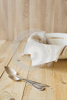 Two tablespoons on background of linen cloth in the bowl