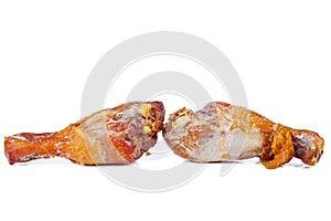 Two tainted smoked chicken legs on a white