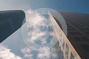 Two Tall Corporate Sky Scrapers with Blue Sky and Clouds