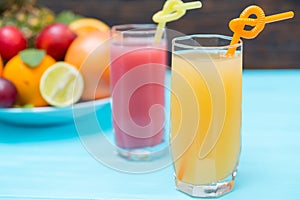 Two tall glasses of freshly squeezed fruit juice