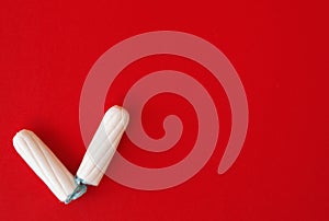 Two tampons on a red background.