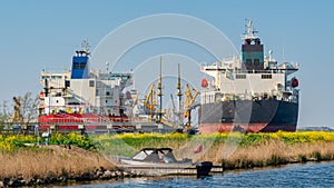 Two tankers in Amsterdam harbor and a small private vessel