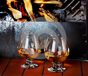 Two tanks of cognac on old brick fireplace with bright fire