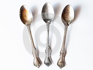 Two tarnished and one clean vintage silver spoons