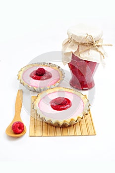 Two tarts and jar of raspberry jam