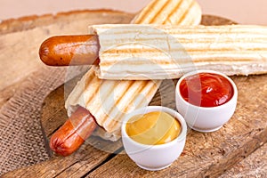 Two tasty grilled french hot dog with mustard and ketchup