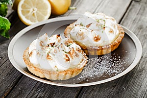 Two tasty lemon Meringue Tartlets with mint