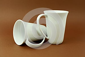Two tea cups on brown background