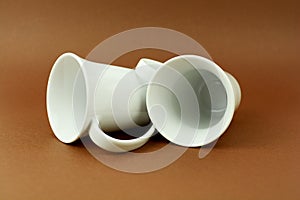 Two tea cups laying on brown background