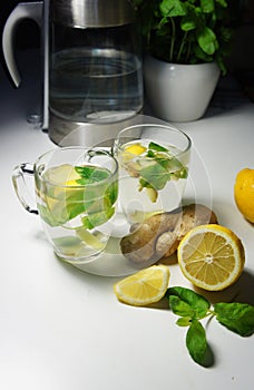 Two teacups with fresh peppermint, ginger and lemon