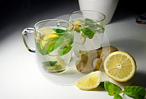 Two teacups with fresh peppermint, ginger and lemon