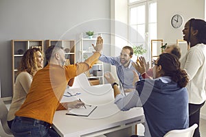 Two teams of happy diverse business people making a deal, high fiving and applauding