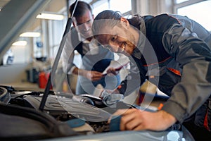 Two technicians doing car diagnostics together