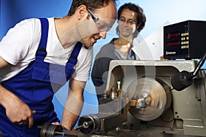 Two technicians on lathe machine in workshop photo