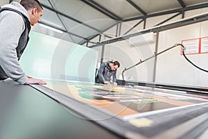 Two technicians works on CNC computer numerical control cutting machine